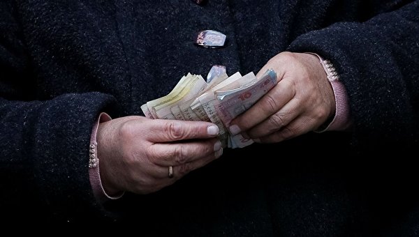 Пожилая женщина считает деньги в центре Львова