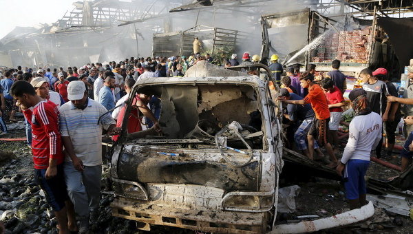 Местные жители на месте взрыва грузовика на переполненном рынке в Багдаде
