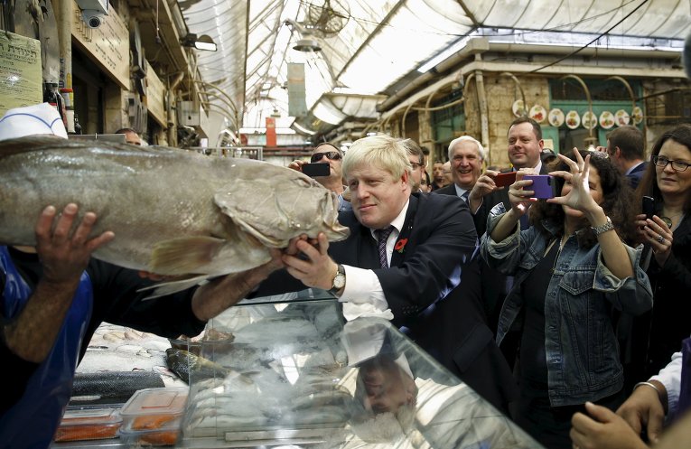 Мэр Лондона Борис Джонсон выбирает рыбу на рынке Иерусалима