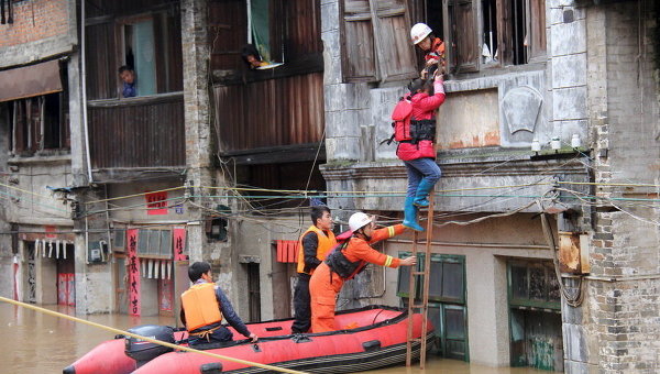 Спасатели пытаются помочь женщине в затопленном после обильных дождей Хэчжоу, Китай