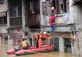 Спасатели пытаются помочь женщине в затопленном после обильных дождей Хэчжоу, Китай