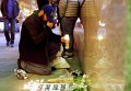 Мужчина ставит свечу возле Генерального консульства Франции