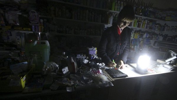 Продавец работает в хозяйственном магазине при свечах из-за отключения электричества в Симферополе