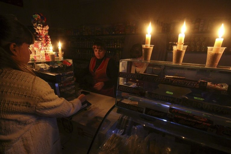 Покупатель и продавец в бакалейном магазине, работающем при свечах в Симферополе