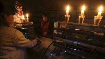 Покупатель и продавец в бакалейном магазине, работающем при свечах в Симферополе