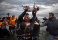 Волонтеры на Лесбосе спасают беженцев с Ближнего Востока, переправившихся из Турции.