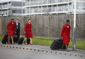 Стюардессы с багажем идут к подъездному тоннелю в аэропорту Хитроу на западе Лондона