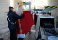 Полиция обыскивает немца Вольфганга Киммиг-Либе, который уже который год вытсупает в роли Санта-Клауса, перед входом на площади Святого Петра в Ватикане