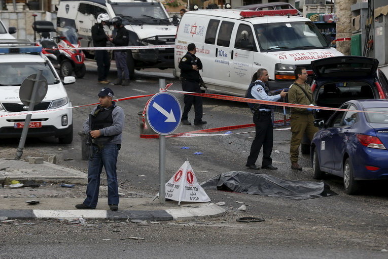 Израильские солдаты и полицейские рядом с телом убитого палестинца на контрольно-пропускном пункте возле села на Западном берегу Хизма