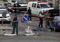 Израильские солдаты и полицейские рядом с телом убитого палестинца на контрольно-пропускном пункте возле села на Западном берегу Хизма