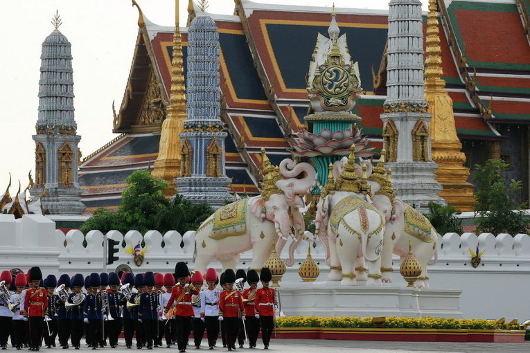 Тайские королевские гвардейцы маршируют у Большого дворца во время военного парада в рамках празднования предстоящего дня рождения короля Пумипона Адульядета в Бангкоке