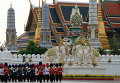 Тайские королевские гвардейцы маршируют у Большого дворца во время военного парада в рамках празднования предстоящего дня рождения короля Пумипона Адульядета в Бангкоке