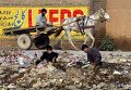 Пакистанские подростки роются в куче мусора в Пешаваре