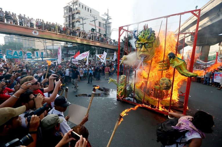 Протестующие сжигают чучело президента Филиппин и других членов правительства в ознаменование  67 годовщины подписания Декларации прав человека.