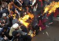 Активисты из оппозиционной партии Национальный конгресс Индии спасаются от огня. Во время акции протеста они пытались сжечь чучело премьер-министра Индии Нарендра Моди.