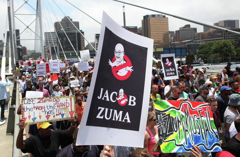 Демонстранты принимают участие в марше протеста на мосту Нельсона Манделы в Йоханнесбурге