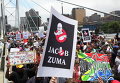 Демонстранты принимают участие в марше протеста на мосту Нельсона Манделы в Йоханнесбурге