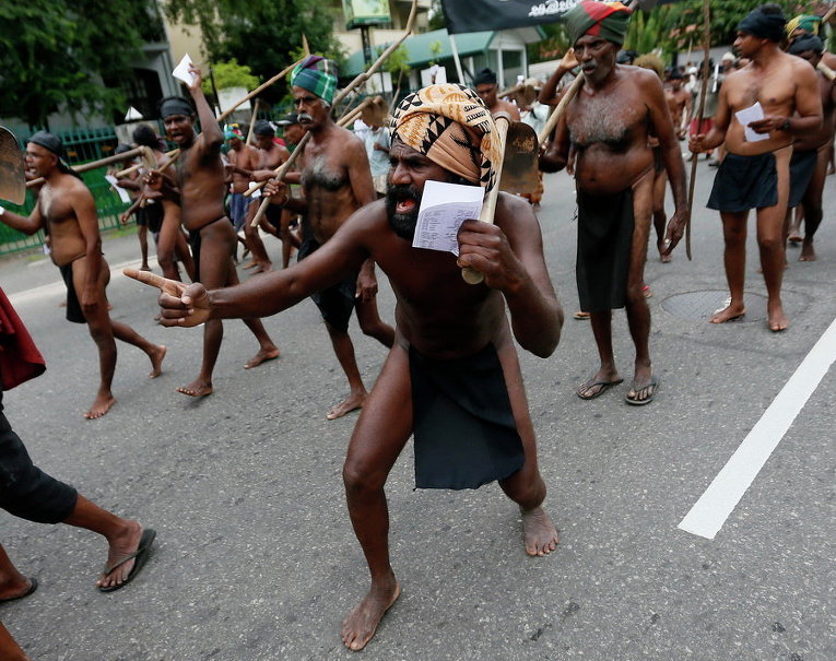 Шри-ланкийские фермеры в традиционных нарядах выкрикивают лозунги во время акции протеста против бюджета 2016 года в Коломбо, Шри-Ланка
