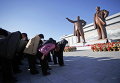 Северокорейцы кланяются бронзовым статуим лидеров Ким Чен Иру и его отцу, Ким Ир Сену