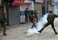 Индийские полицейские и мусульманские демонстранты в ходе акции протеста в Сринагаре, Кашмир