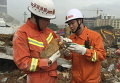 Пожарные пытаются напоить курицу, которая была спасена из-под обломков рухнувшего здания после оползня в Шэньчжэне, Китай