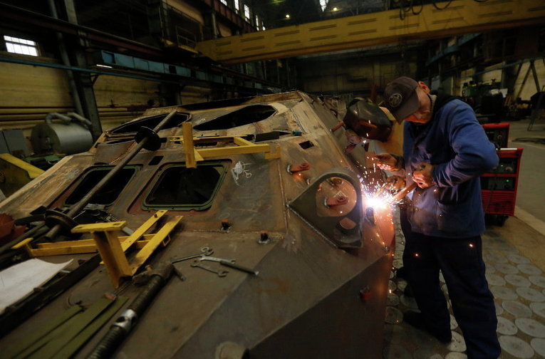 Сварщик сваривает детали на бронированном автомобиле на танковом заводе в Киеве, Украина