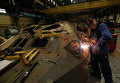 Сварщик сваривает детали на бронированном автомобиле на танковом заводе в Киеве, Украина