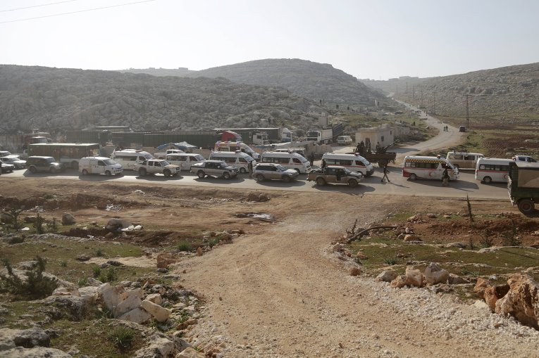 Бойцы из коалиции повстанческих групп под названием Аль-Фатх Джайш сопровождают автомобили сирийской скорой помощи Арабский Красный Полумесяц