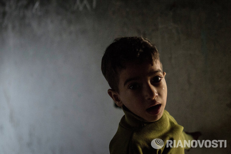 Ребенок беженцев в районе Ярмук в Дамаске