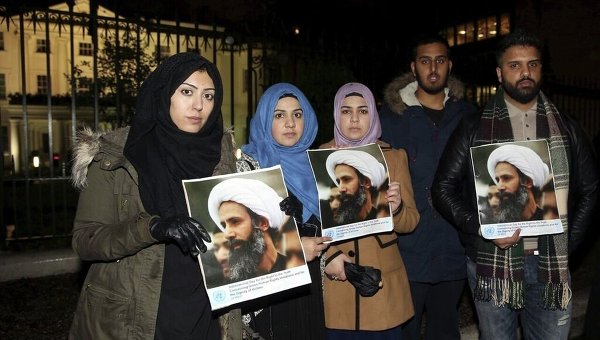 Демонстранты держат фотографию казненного проповедника шейха Нимр ан-Нимра возле посольства Саудовской Аравии в Лондоне