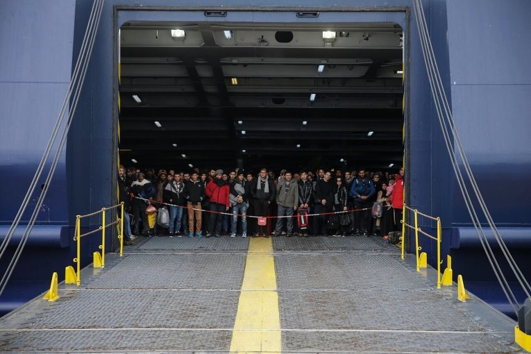 Беженцы и переселенцы на борту пассажирского парома Ariadne в порту Пирей, недалеко от Афин (Греция)