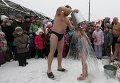 Житель российского Красноярска Григорий Броверман, член группы зимних пловцов клуба Cryophile, выливает ведро ледяной воды на свою 6-летнюю дочь Лизу при температуре воздуха минус 5.