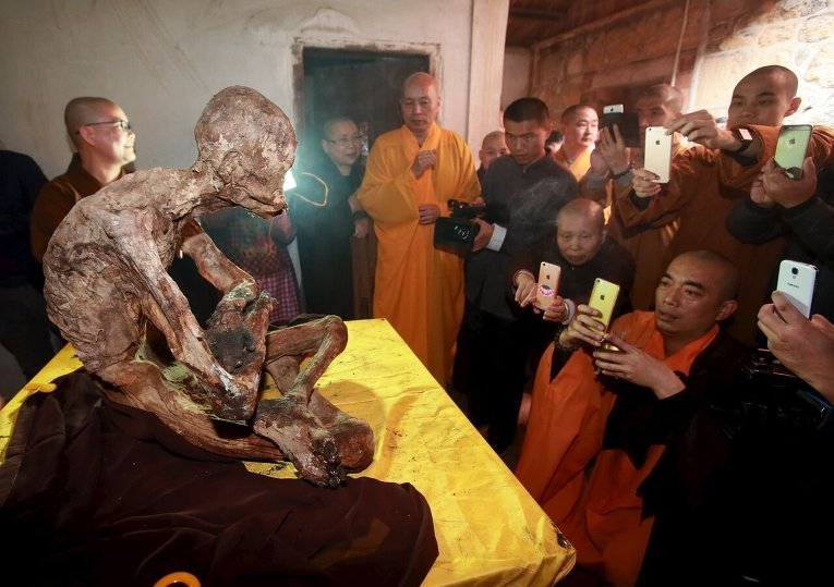 Монахи в Цюаньчжоу фотографируют мумию монаха.