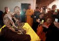 Монахи в Цюаньчжоу фотографируют мумию монаха.