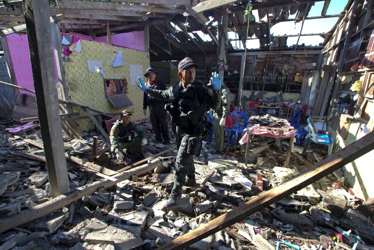 Военнослужащие осматривают место взрыва бомбы в южной провинции Сонгкхла, Таиланд. В результате теракта один человек был убит и один ранен.