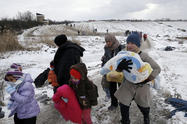 Мигранты на заснеженном поле в Сербии после пересечения македонской границы