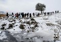 Мигранты на заснеженном поле после пересечения границы в Македонии