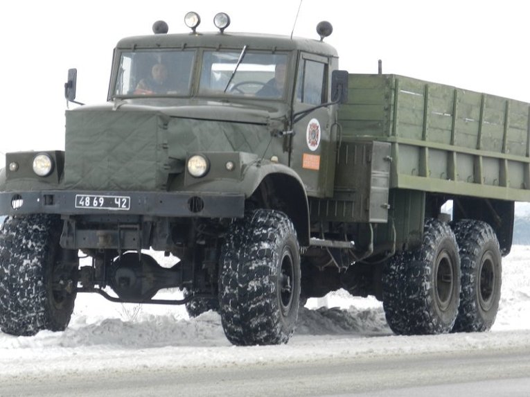 На автомобилях КрАЗ и КамАЗ спасатели буксируют на участках, сильно заметенных снегом, автовышки энергетиков в Херсонской области