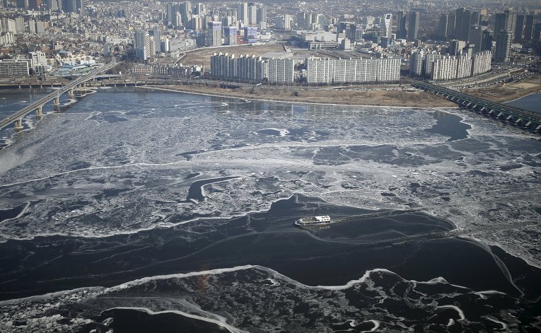 Пассажирское судно проходит реку Ханган в Сеуле, Южная Корея,  температура воздуха в стране опустилась ниже 18 градусов.