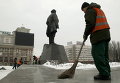 Работники подметают улицу рядом с памятником Ленину, который был частично поврежден при взрыве в центре Донецка