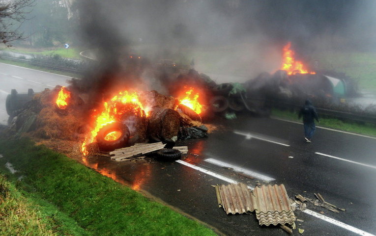 Французские фермеры устроили горящую баррикаду через национальное шоссе в Кемпер в рамках широкомасштабных протестов против падения цен на их продукцию