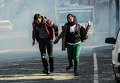 Жители бегут в укрытие от слезоточивого газа, выпущенного силами безопасности после введения комендантского часа в Сурат, Турция
