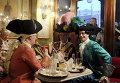 Люди в карнавальных костюмах в кафе на площади Сан-Марко во время Венецианского карнавала, Италия