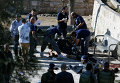 Офицеры израильской полиции осматривают тело одного из застреленных палестинцев, который напал на полицейских.