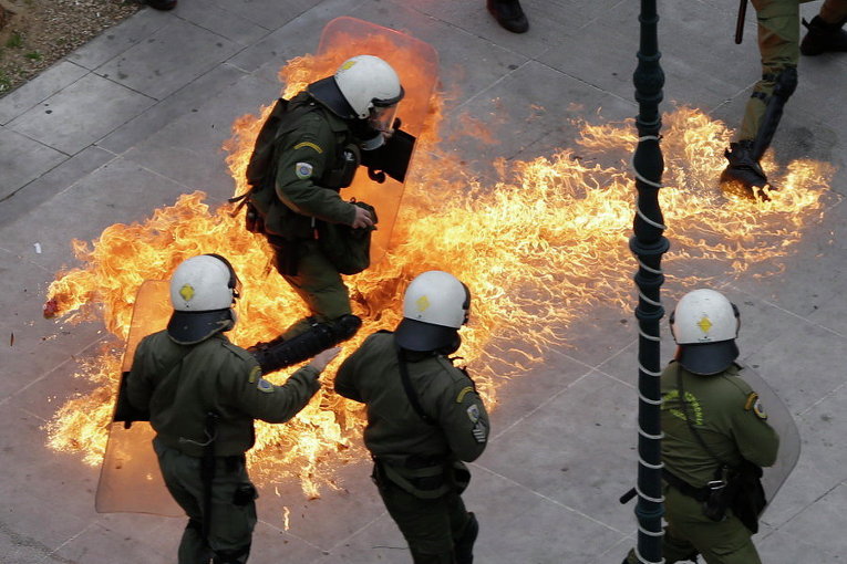 Протестующие во время 24-часовой общенациональной общей забастовки в Афинах бросают в полицейских коктейли Молотова