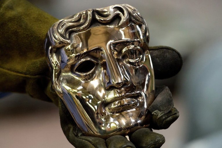 Технический директор литейного завода держит маску BAFTA, Англия