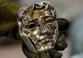 Технический директор литейного завода держит маску BAFTA, Англия