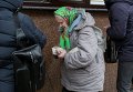 Пожилая женщина покупает продукты в центре Киева.