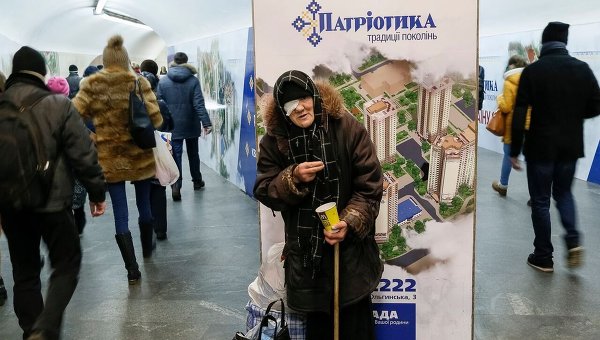 Пожилая женщина просит милостыню в метро Киева.
