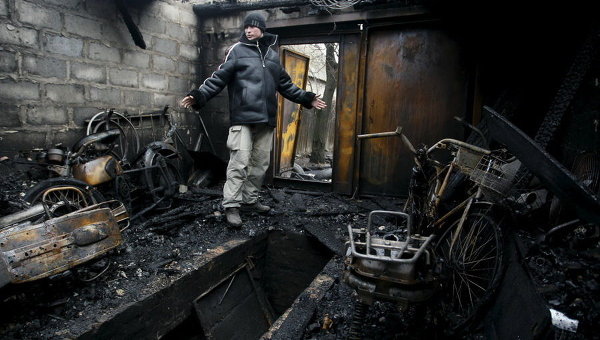 Местный житель в своем гараже, который был разрушен во время перестрелки между украинскими правительственными силами и ополченцами, на окраине Донецка